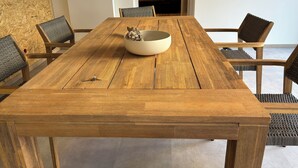 A wooden dining table with a white bowl and a key on it, surrounded by four chairs with woven seats. - Exclusive apartment, central location 10min to the harbor (Sassnitz)