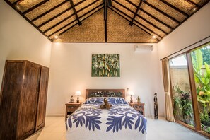 A bedroom with a large bed, wooden wardrobe, and a ceiling with a woven pattern. - Sujaya Villas (Ubud)