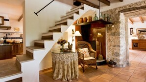 Eine Treppe führt zu einem Essbereich mit einem Korbstuhl und einem Tisch mit einer Spitzentuchdecke.