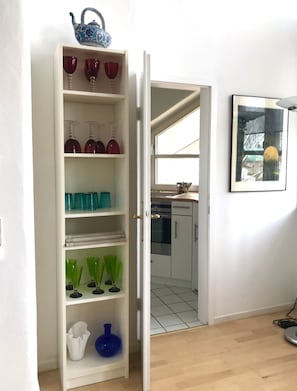 A kitchen with white cabinets, a countertop, and a window. - Studio apartment in a dreamy and quiet garden in the immediate vicinity of the lake (Schondorf am Ammersee)