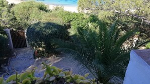 Une vue sur la côte, avec une plage de sable, des falaises rocheuses et une mer bleue et limpide.