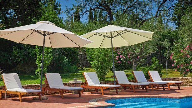 A poolside area with lounge chairs and umbrellas.