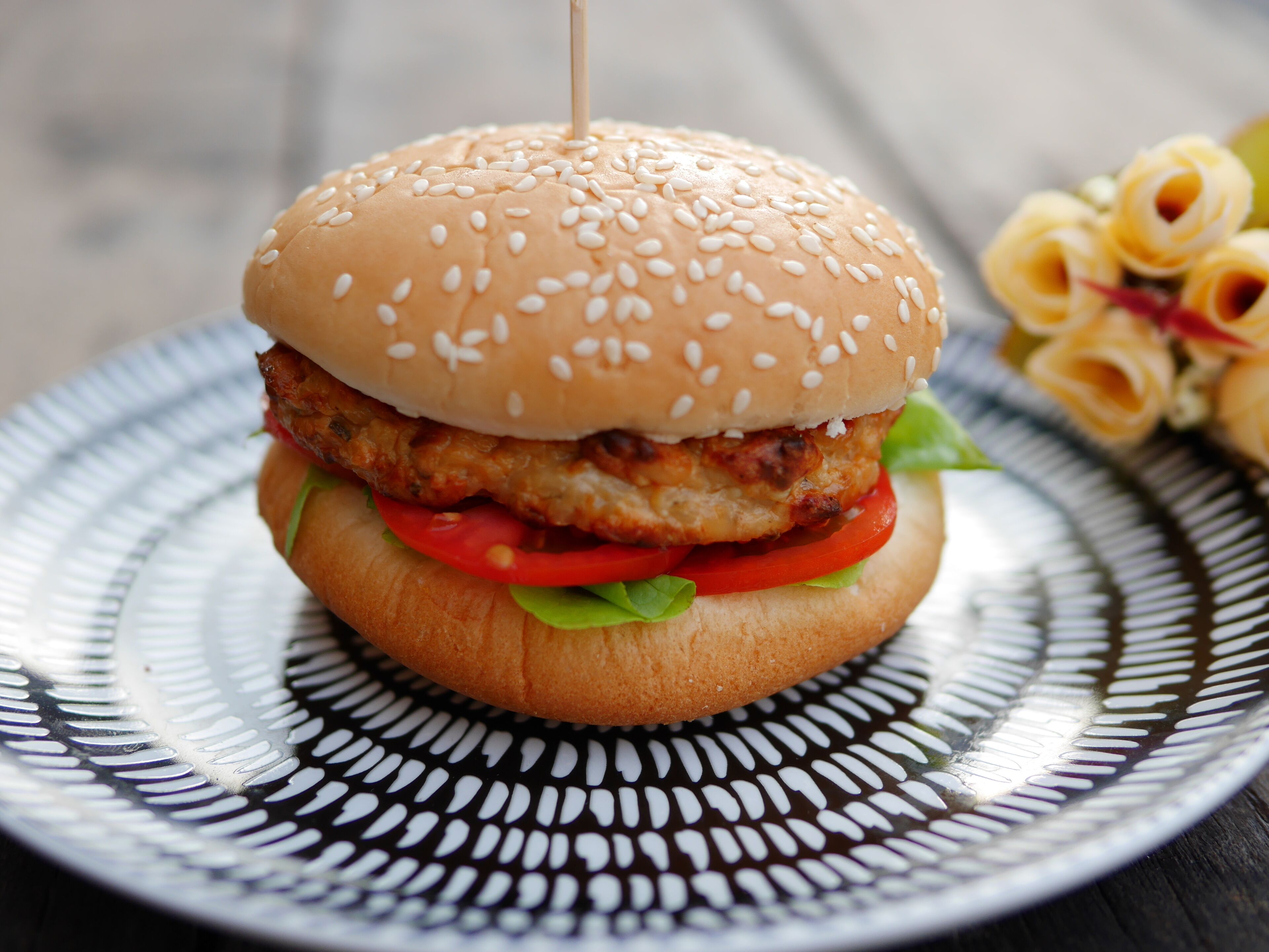 Un hamburger de pollastre sobre un plat estampat.