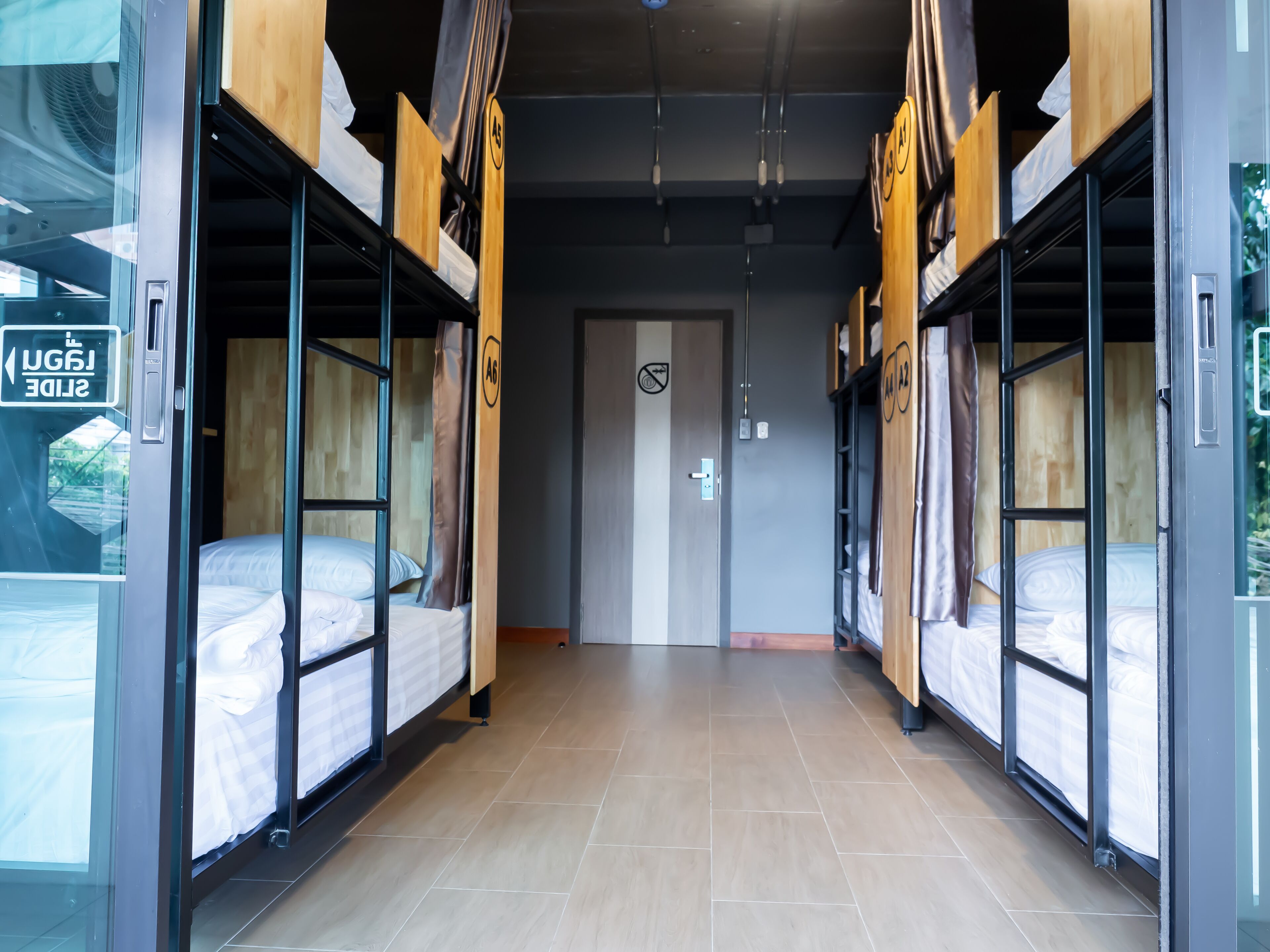 A corridor with bunk beds, a door with a no-smoking sign, and a sign reading "SLIDE".