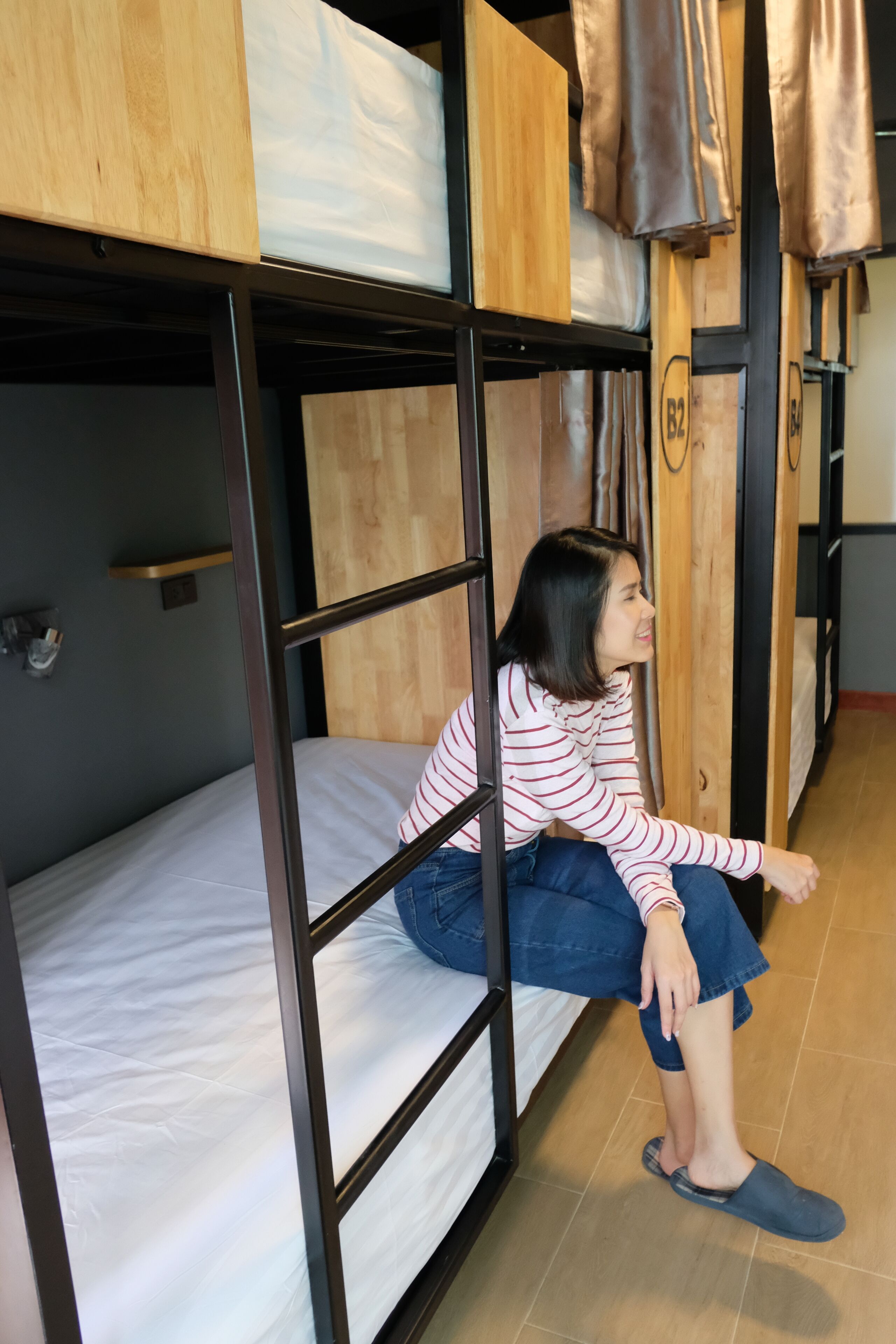 Habitación con literas y una persona sentada en la cama inferior.