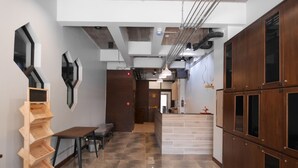 A modern hotel corridor with a wooden bench, a wall-mounted shelf, and a kitchen area with cabinets labeled A1-A4. - Ray Hostel (Chiang Mai)