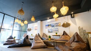 A modern interior with bean bags, wicker lamps, and artwork on the walls. - Lopi Hotel (Makassar)