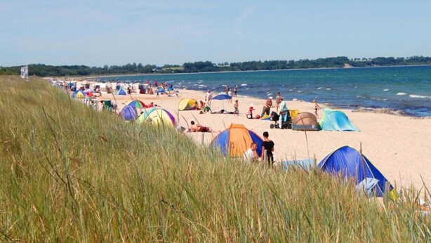 A beach with tents and people.