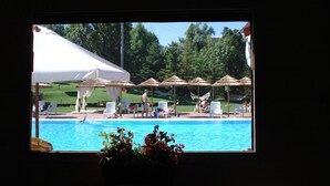 Un espace piscine équipé de parasols et de chaises longues.