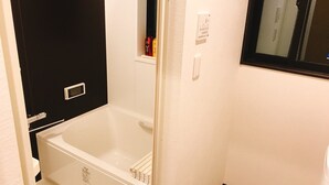A bathroom with a white bathtub, a black door, and a small window. - GH One More Heart Enmachi 3 (Kyoto)