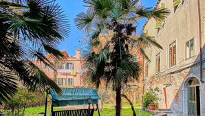 A courtyard with a bench, a grill, and a building with arched windows. - Venetian palazzo near St. Mark's Square & Arsenal, canal view, free Wi-Fi (Venezia)