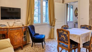 A dining area with a chandelier, a television, and a table set for four. - Venetian palazzo near St. Mark's Square & Arsenal, canal view, free Wi-Fi (Venezia)