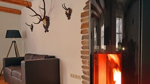 Una sala de estar acogedora con sofá de cuero, chimenea y decoración de cornamenta.