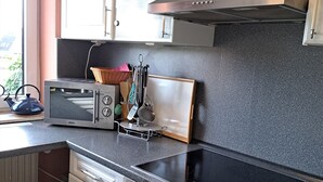A kitchen with a microwave, toaster, and stove. - Vacation apartment for up to 8 people, 140 sqm, 2 WCs, directly on the L.Heide nature reserve (Bispingen)