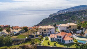 Zona residencial costera con casas de techo rojo y vista al mar.