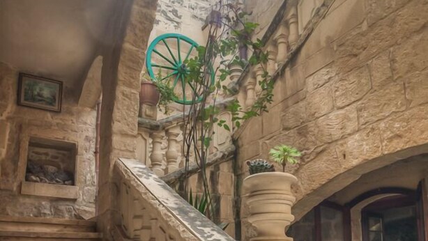 Una escalera de piedra con barandillas ornamentales que conduce a una puerta.