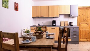 Une cuisine moderne avec des meubles en bois, une table à manger dressée avec des assiettes, des tasses et un panier de pain.