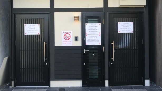 A hotel entrance with two black doors, a 'DANGER' sign, and a 'No Smoking' sign. - GH One More Heart at Toji 3 (Kyoto)