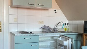 Een keuken met een geïntegreerde koelkast, een spoelbak en kastjes.