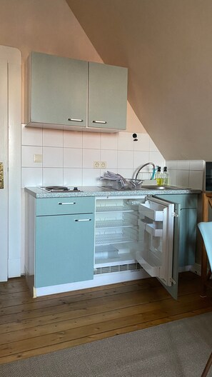 A kitchen with a built-in refrigerator, a sink, and cabinets.