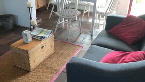 Una sala de estar con sofá, mesa de centro y comedor con sillas y mesa.