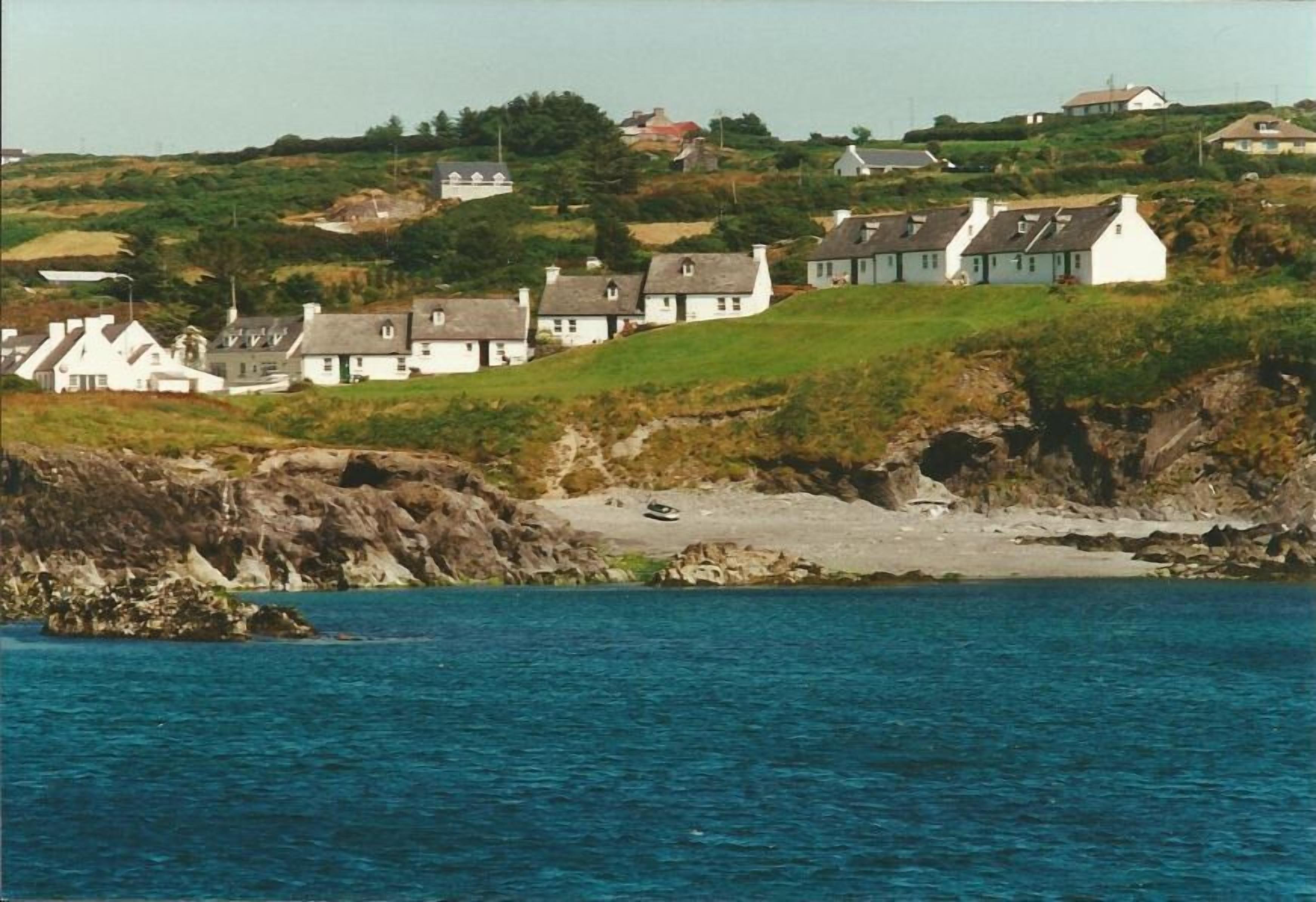 Un village côtier avec des maisons construites sur une colline, d’où l’on a une vue sur la mer.