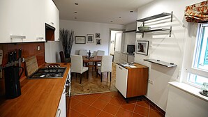 Una cucina compatta con fornelli, lavandino e zona pranzo.