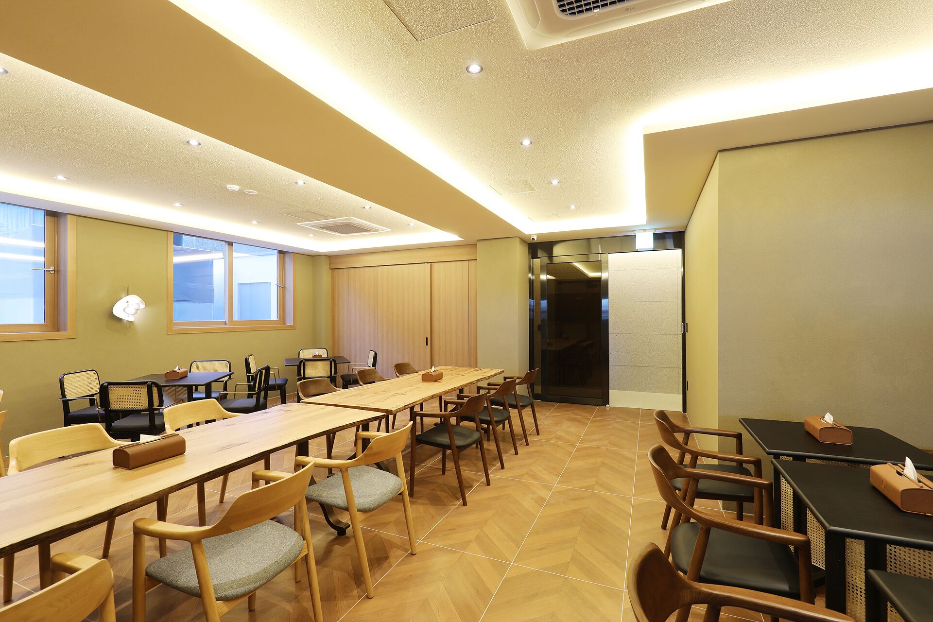 A conference room with a long table, multiple chairs, and a large window.
