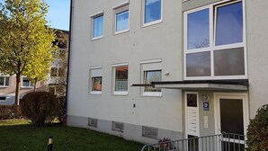 A multi-story building with a flat facade, multiple windows, and a small entrance with a door. - Cozy city apartment with carport for 2 to 5 people near the thermal baths (Bad Reichenhall)