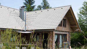 A rustic log cabin with a sloped roof, stone foundation, and a small porch.