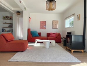 A modern living room with a sofa, coffee table, and a black cabinet. - Old Boucau les Bains Villa  (Vieux-Boucau-Les-Bains)