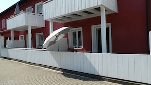 A red building with white balconies and a white fence. - Allgäutraum Apartment No. 1 for 2-4 people in Durach-Weidach (Oberkottern)