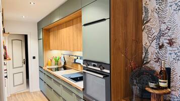 Eine moderne Küche mit Einbauofen, Spüle und Holzschränken.