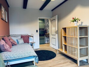 A bedroom with a bed, bedside table, lamp, and a wooden cabinet.
