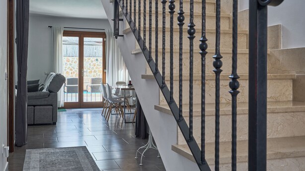 A staircase with black balusters leading to a landing.