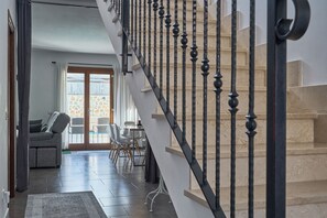 Un escalier avec des balustrades noires menant à un palier.