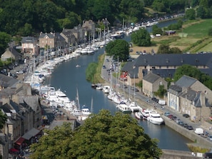 A riverside town with a marina filled with boats, historic stone buildings, and a narrow road alongside the water. - Family house NEAR RANCE, South facing garden (Pleurtuit)