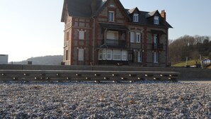 A large, multi-story house with a prominent balcony and a stone facade. - !!!Studio less than 50 meters from the sea !!!28 € / Night and 35 € / summer for 2 people (Veulettes-sur-Mer)