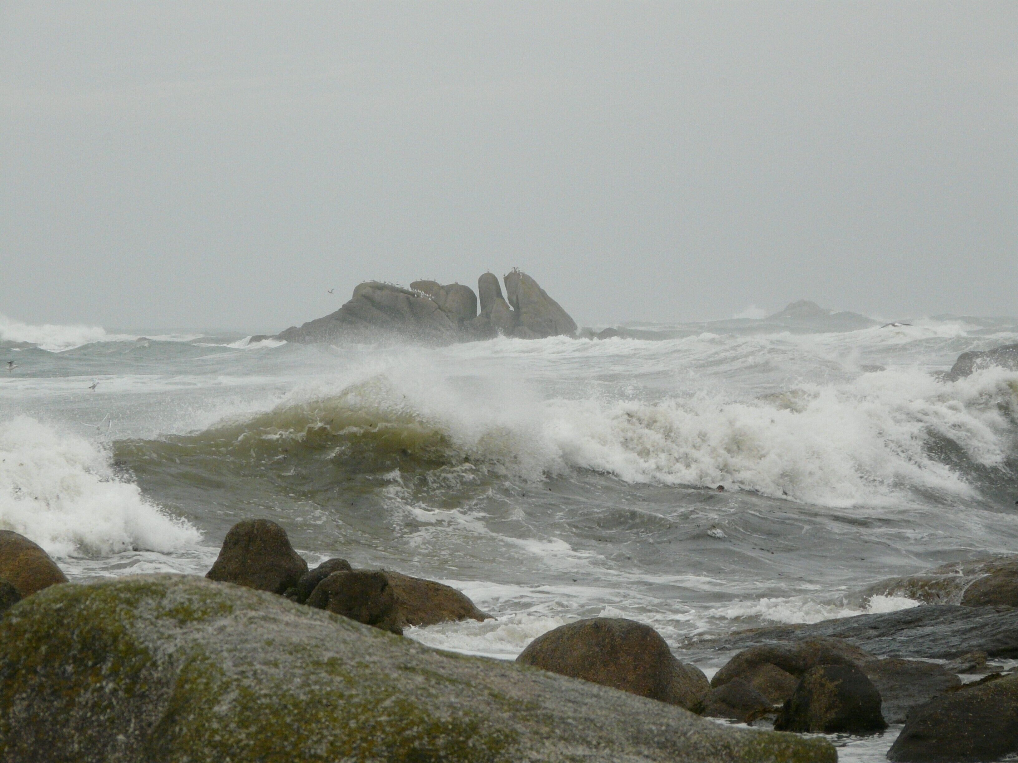 A rocky shoreline with waves crashing against the rocks.
