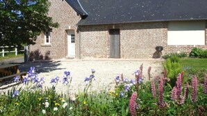 Un bâtiment en briques avec un toit gris, une porte blanche et une petite fenêtre.
