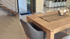 Ein moderner Essbereich mit einem Holztisch, grauen Polsterstühlen und einer dekorativen Schale auf dem Tisch.