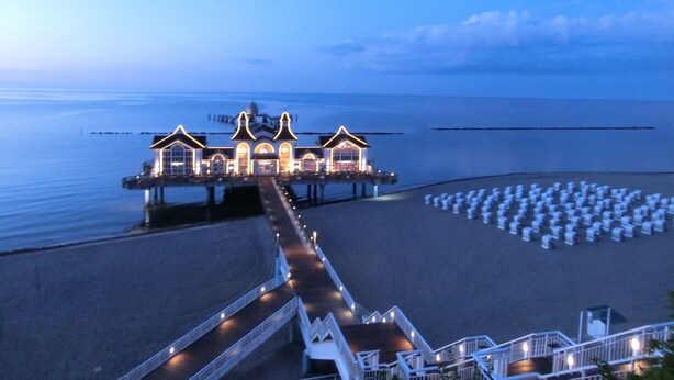 A seaside hotel with a pier extending into the water, featuring a central building with multiple arches and a smaller structure at the end. - family-friendly non-smoking house with large garden and beautiful view (Ralswiek OT Gnies)