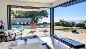 A modern interior with a large glass door leading to an outdoor pool area. - Luxury villa, sea view - swimming pool facing the sunset (Corbara)