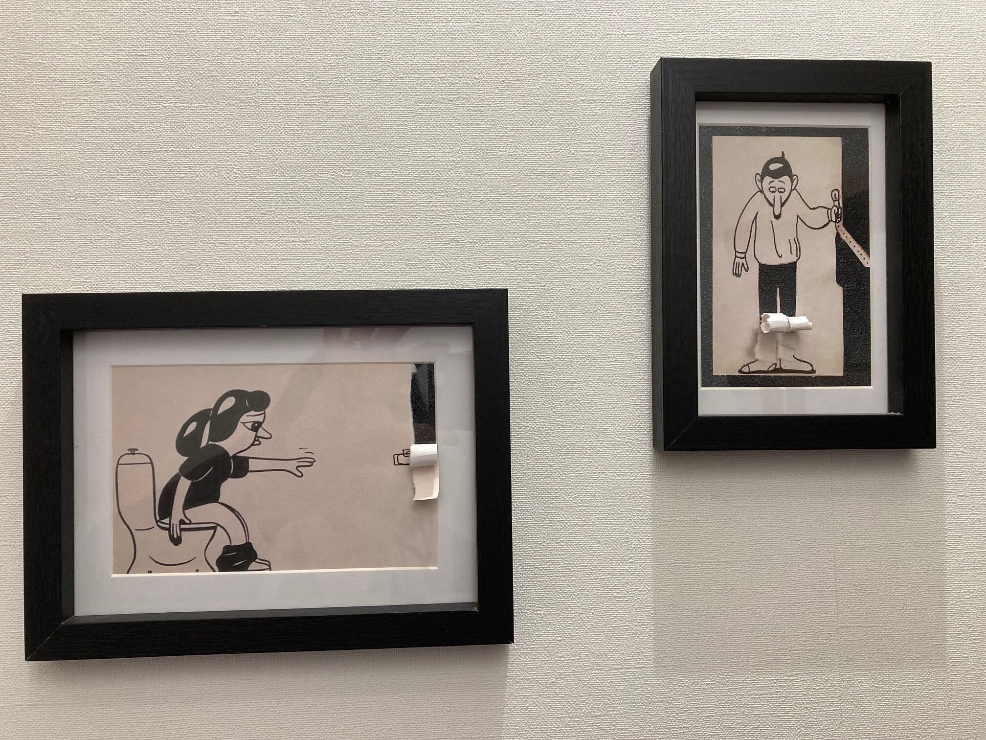 Dos ilustraciones en blanco y negro, enmarcadas, sobre una pared texturizada.