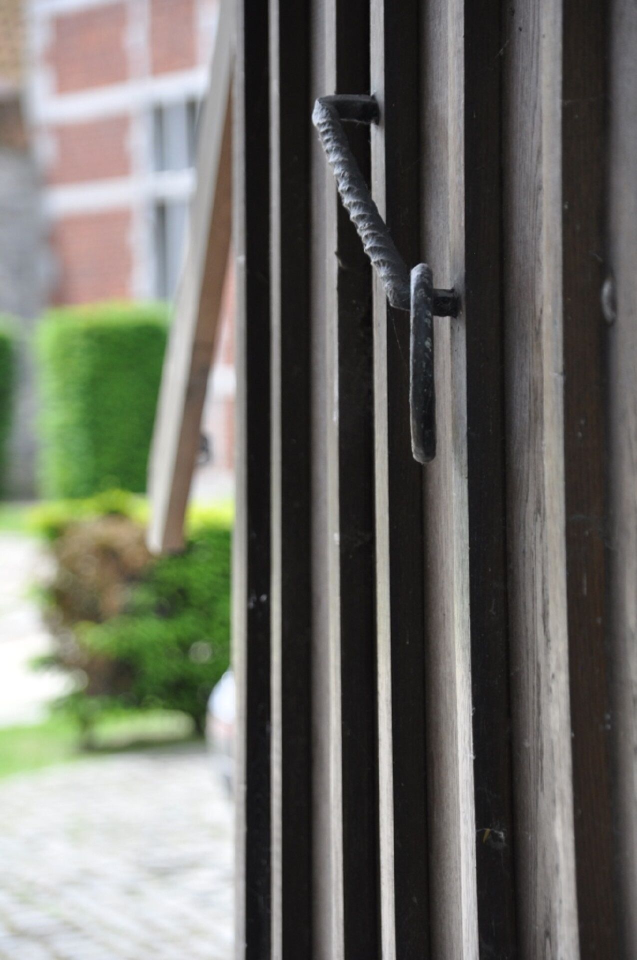 Une porte métallique dotée d’une poignée, qui fait partie de l’extérieur d’un bâtiment.