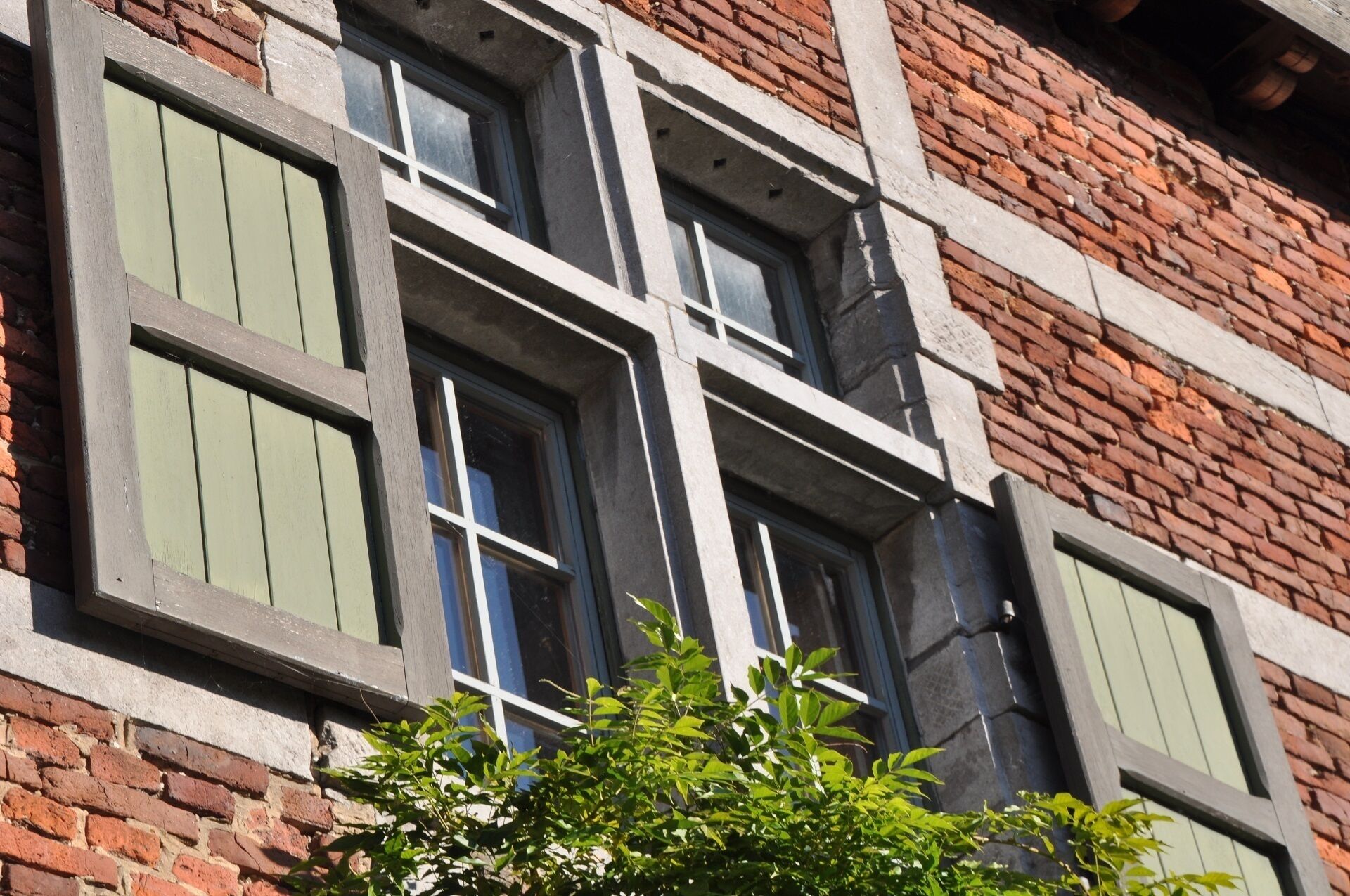 Un edificio de ladrillo con múltiples ventanas de marco blanco.