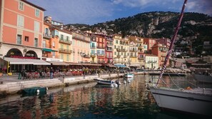 A waterfront with colorful buildings, a marina with boats, and outdoor seating areas. - Charming villa, yet affordable, in Villefranche-sur-mer, the real Cote d’Azur. (Villefranche-sur-Mer)