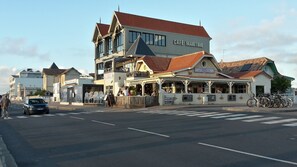 A coastal building with a café named "Café Maritime" and a restaurant named "Le Village de la Mer."
