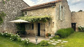 Experience the authentic charm of this traditional Mediterranean-style building, surrounded by a beautifully maintained garden and patio area.