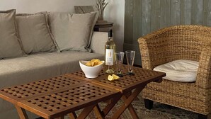 A living room with a wooden table, a wicker chair, a sofa, and a lamp. - RARE CHARMING APARTMENT IN OLD NICE, WITH A GARDEN VIEW, CLOSE TO THE SEA (Nice)